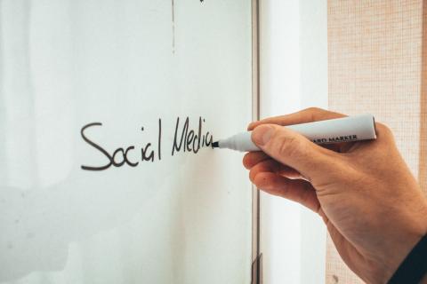 En hånd skriver på en whiteboard