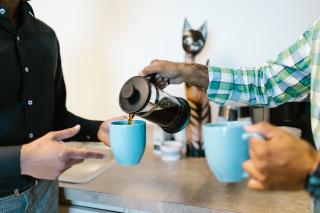 To kolleger skænker kaffe i en pause