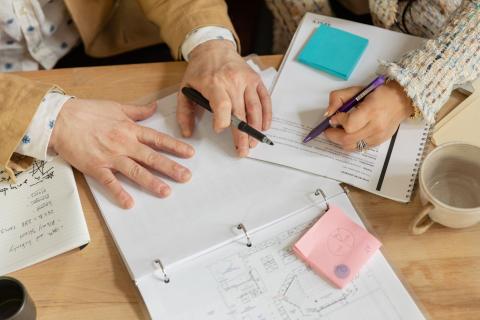 Hænder, der planlægger med noter og sticky notes